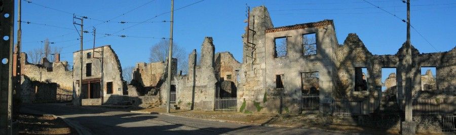 Entrée Est, les ruines de la rue principale avec les rails de la voie et les câbles de la caténaire du tramway départemental de Limoges - Wikimedia Commons - JLPC - CC0